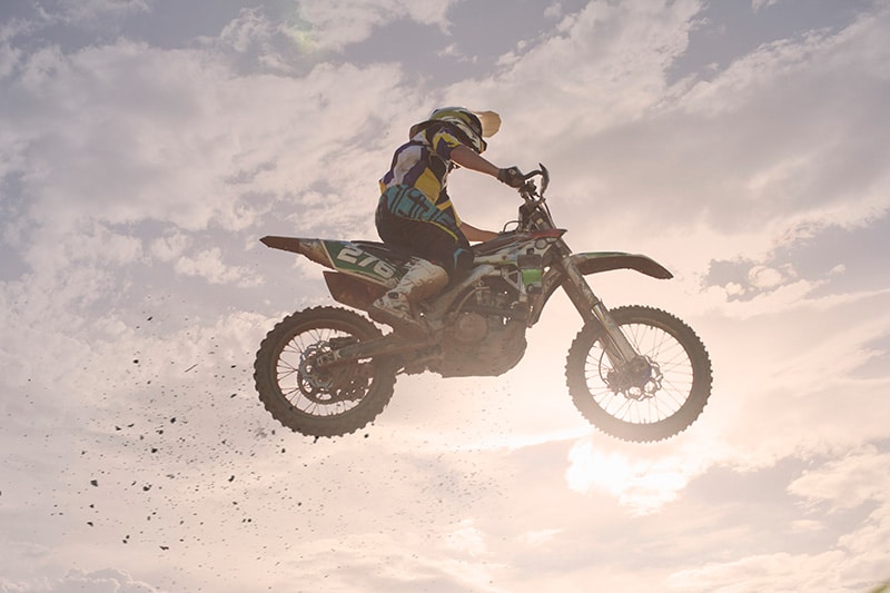 Rennfahrer springt mit einem Honda Mini Bike ähnlichen Motocross in die Luft
