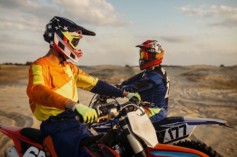 Zwei Fahrer in passender Motocross Bekleidung unterhalten sich